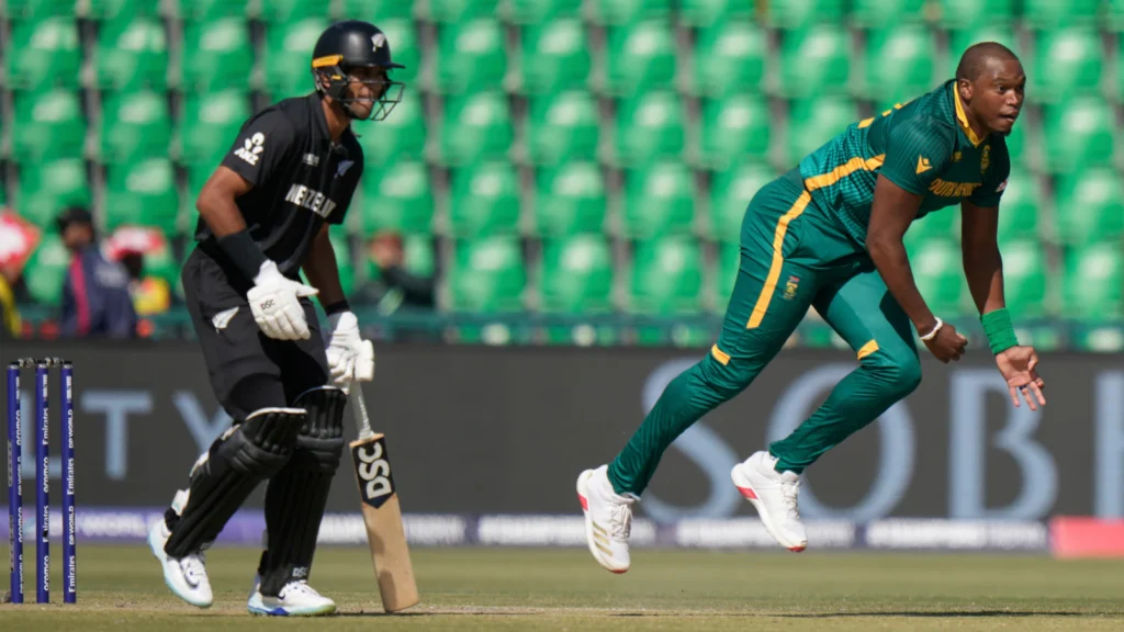 South Africa vs New Zealand cricket match in action, players competing on the field under stadium lights, with a packed crowd cheering in the background."