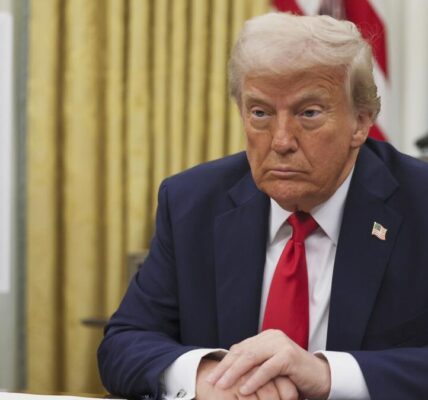 A news graphic featuring former President Donald Trump with a backdrop of shipping containers and financial charts, symbolizing the impact of upcoming tariffs on global trade.